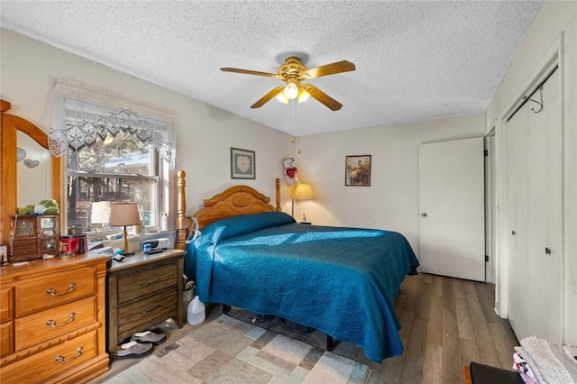 bedroom featuring hardwood / wood-style floors, a textured ceiling, ceiling fan, and a closet