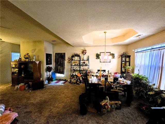 dining area with a raised ceiling, a textured ceiling, and carpet