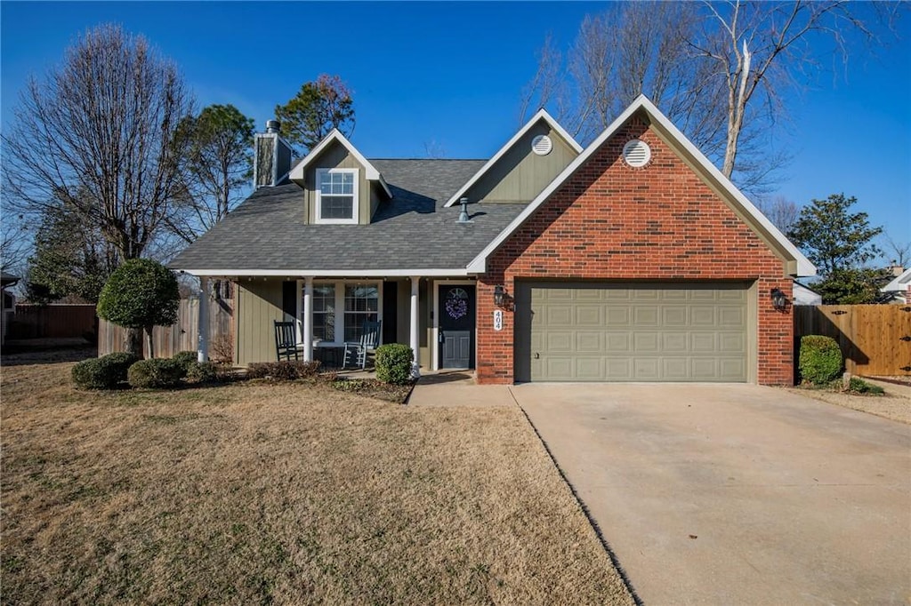 view of front of home with a garage, covered porch, and a front lawn