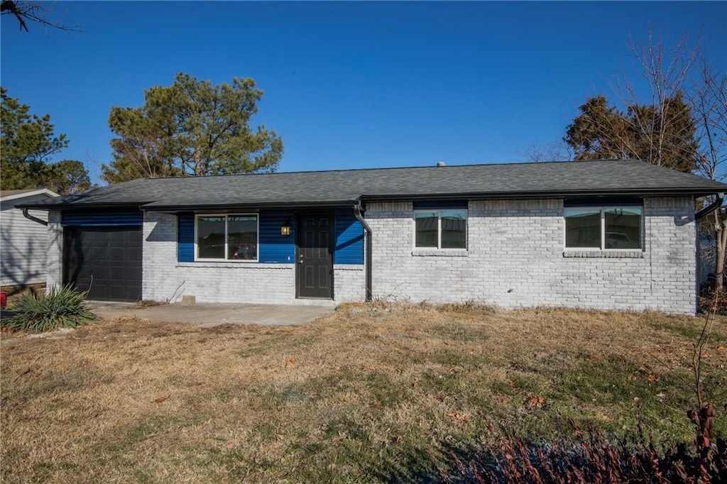 single story home with a garage and a front lawn