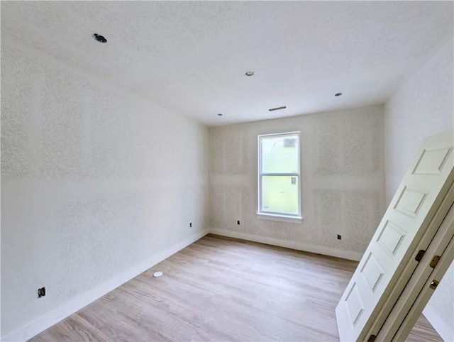 17 Burnham Dr, Bella Vista, AR 72715 - unfurnished room featuring baseboards, light wood-style floors, and a textured wall