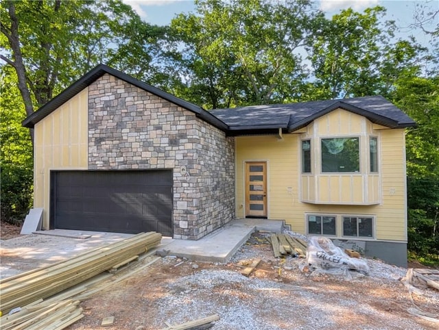 17 Burnham Dr, Bella Vista, AR 72715 - modern home with a garage, stone siding, and driveway