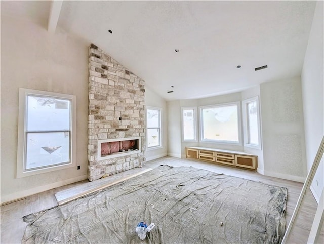 17 Burnham Dr, Bella Vista, AR 72715 - unfurnished living room with wood finished floors, beamed ceiling, baseboards, a fireplace, and high vaulted ceiling