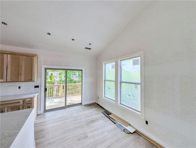 17 Burnham Dr, Bella Vista, AR 72715 - unfurnished dining area featuring lofted ceiling, light wood-style floors, and baseboards