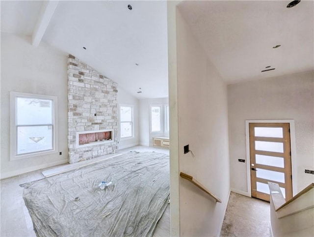 17 Burnham Dr, Bella Vista, AR 72715 - unfurnished living room with beam ceiling, a fireplace, baseboards, and high vaulted ceiling