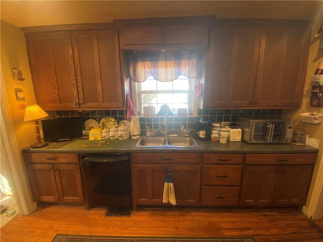 1312 S 9th St, Rogers, AR 72756 - kitchen featuring dishwasher, a sink, wood finished floors, backsplash, and dark countertops