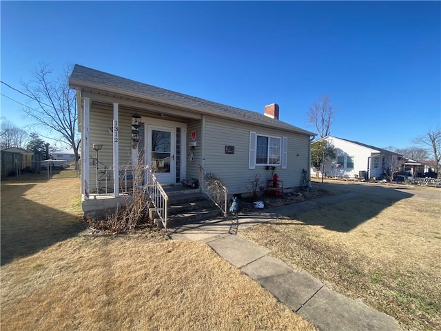 1312 S 9th St, Rogers, AR 72756 - bungalow featuring a chimney, a front lawn, and covered porch
