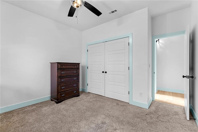 unfurnished bedroom with ceiling fan, light colored carpet, and a closet