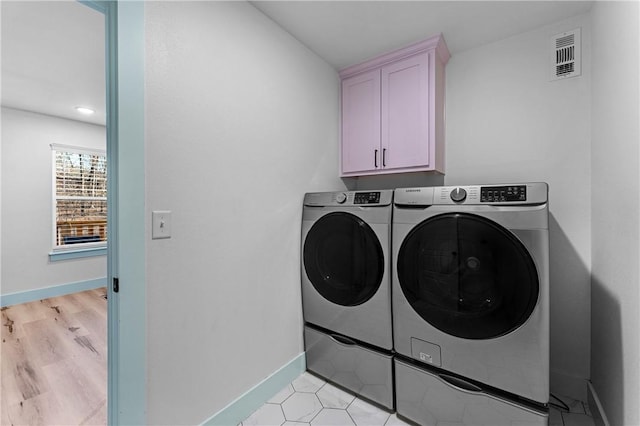 washroom with cabinets and separate washer and dryer