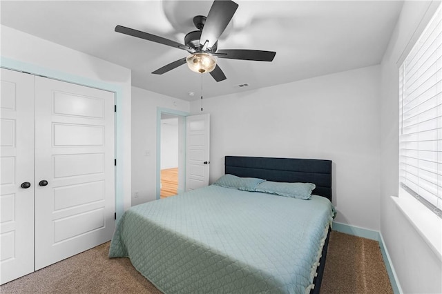 carpeted bedroom featuring ceiling fan and a closet