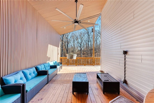 wooden deck with an outdoor living space and ceiling fan