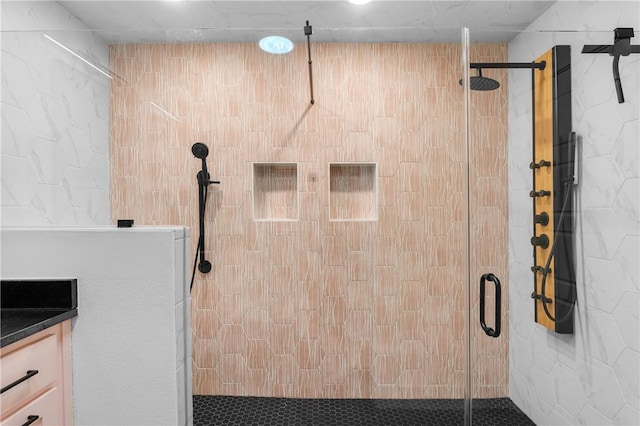 bathroom featuring vanity and a shower with door