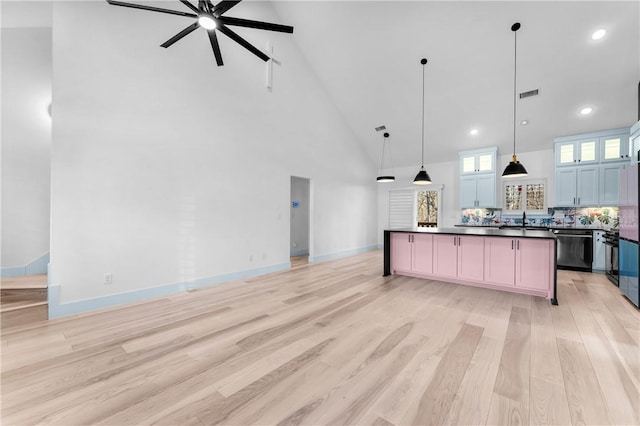 kitchen featuring decorative light fixtures, a center island, high vaulted ceiling, dishwasher, and decorative backsplash