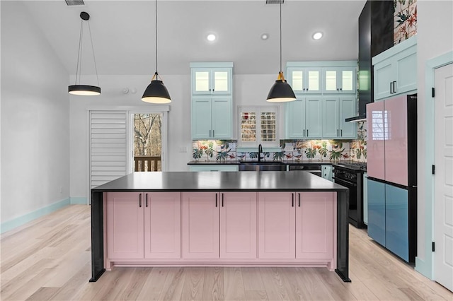 kitchen with pendant lighting, black range oven, refrigerator, decorative backsplash, and light hardwood / wood-style flooring