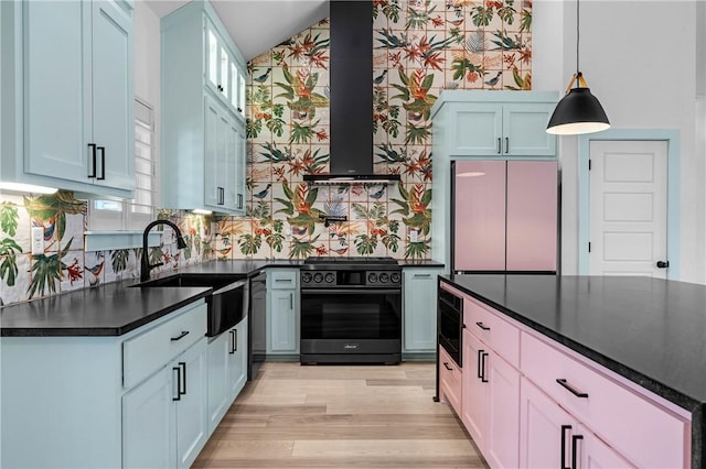 kitchen with sink, fridge, black range with gas stovetop, decorative light fixtures, and wall chimney exhaust hood