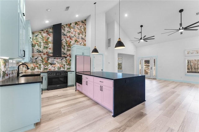 kitchen featuring pendant lighting, sink, a center island, extractor fan, and gas stove