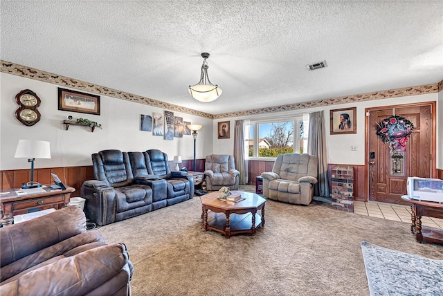 carpeted living room featuring wooden walls and a textured ceiling