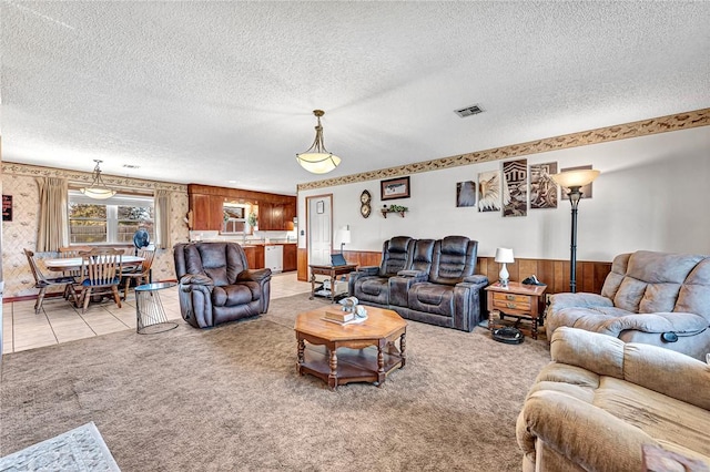 carpeted living room featuring a textured ceiling and wood walls