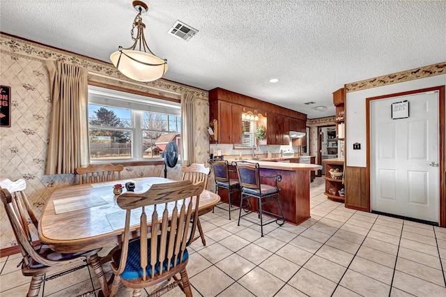 tiled dining room featuring a textured ceiling