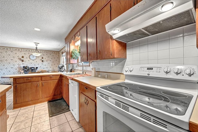 kitchen with sink, white appliances, a textured ceiling, decorative light fixtures, and exhaust hood