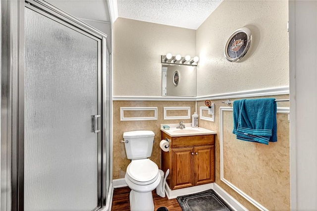 bathroom featuring walk in shower, toilet, a textured ceiling, vanity, and hardwood / wood-style floors