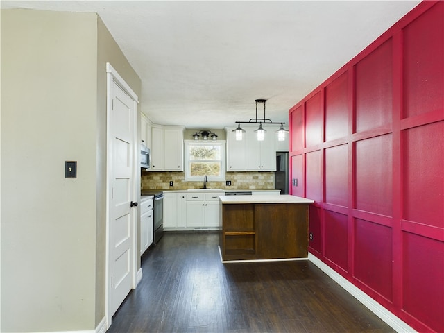 kitchen featuring sink, hanging light fixtures, backsplash, stainless steel appliances, and white cabinets