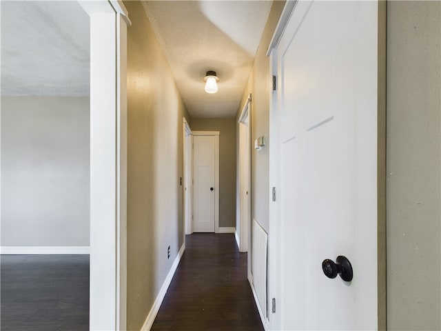 hallway featuring dark hardwood / wood-style flooring and a textured ceiling