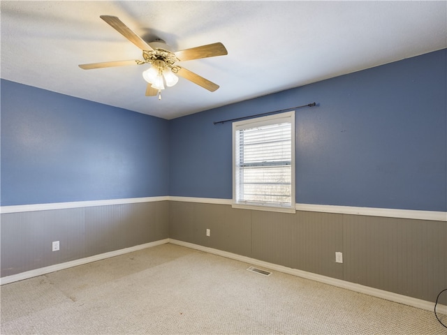 carpeted spare room with ceiling fan