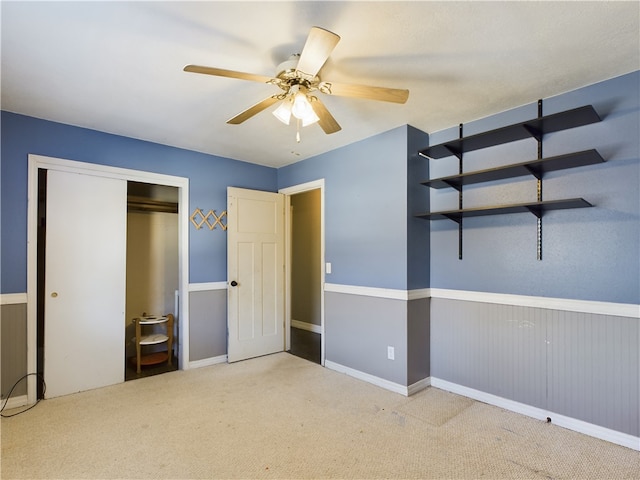 unfurnished bedroom with light colored carpet, a closet, and ceiling fan