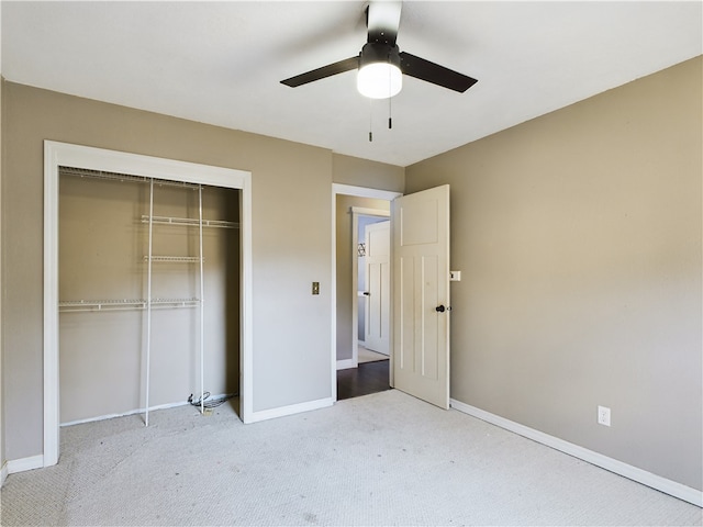 unfurnished bedroom with ceiling fan, light carpet, and a closet