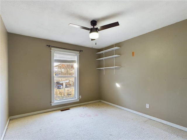 spare room featuring light colored carpet and ceiling fan