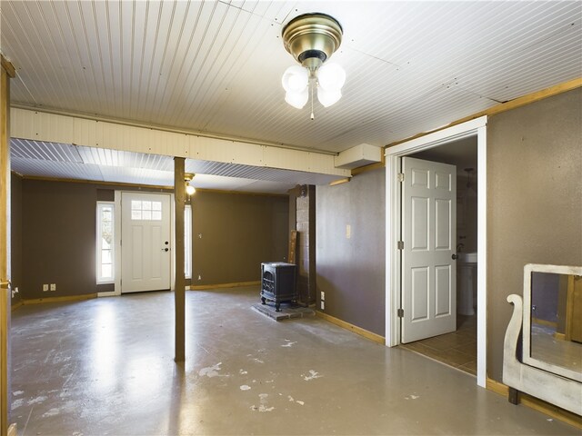 interior space featuring concrete flooring and a wood stove