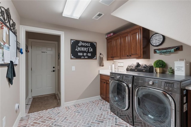 clothes washing area featuring cabinets and washer and dryer