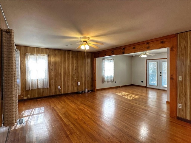 spare room with hardwood / wood-style floors, plenty of natural light, french doors, and ceiling fan