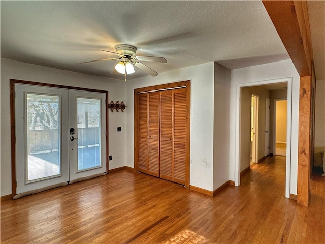 unfurnished bedroom featuring french doors, ceiling fan, access to exterior, and hardwood / wood-style flooring