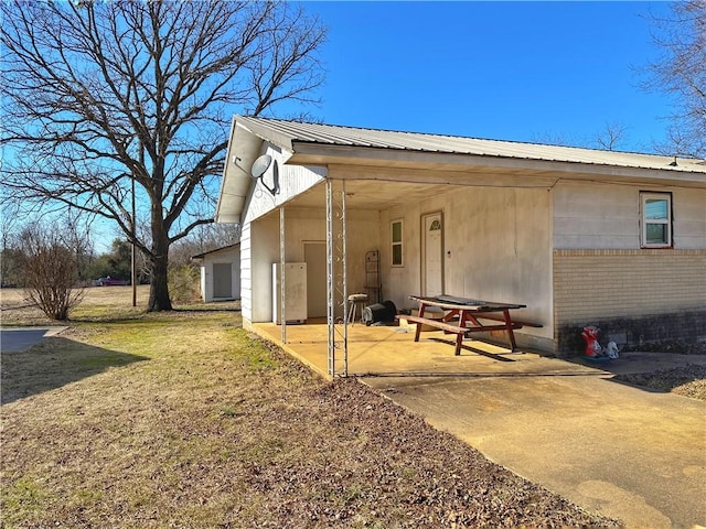 rear view of property featuring a patio area and a lawn