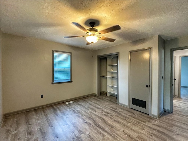 unfurnished bedroom with ceiling fan, a textured ceiling, and light wood-type flooring