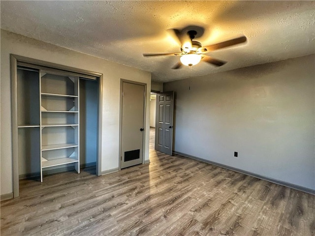 unfurnished bedroom featuring wood-type flooring, a textured ceiling, and ceiling fan