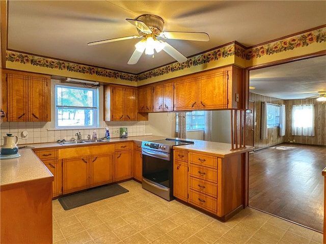 kitchen featuring plenty of natural light, sink, stainless steel range with electric cooktop, and kitchen peninsula