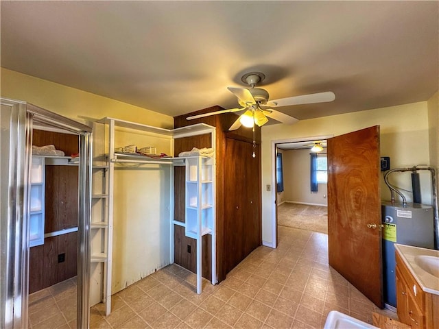 bathroom with water heater, vanity, and ceiling fan