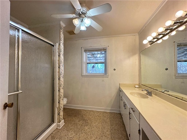 bathroom featuring toilet, a shower with shower door, crown molding, vanity, and ceiling fan