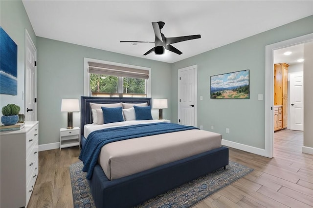 bedroom with connected bathroom, ceiling fan, and light wood-type flooring