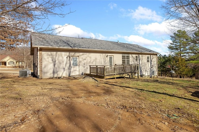 rear view of property with central AC unit, a yard, and a deck