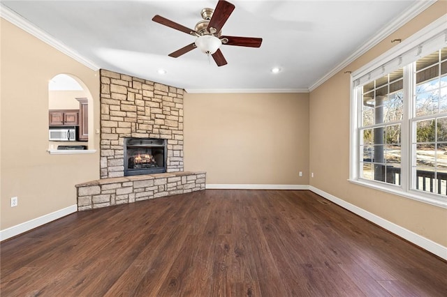 unfurnished living room with dark hardwood / wood-style flooring, crown molding, a fireplace, and ceiling fan