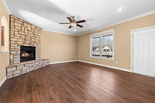 unfurnished living room featuring crown molding, ceiling fan, a stone fireplace, and hardwood / wood-style flooring