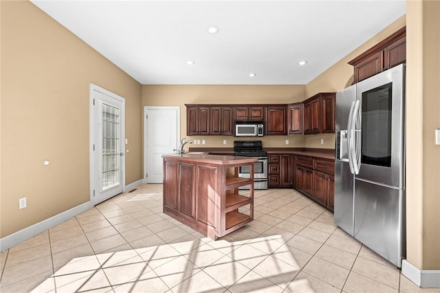 kitchen with a kitchen island with sink, dark brown cabinets, light tile patterned flooring, and appliances with stainless steel finishes