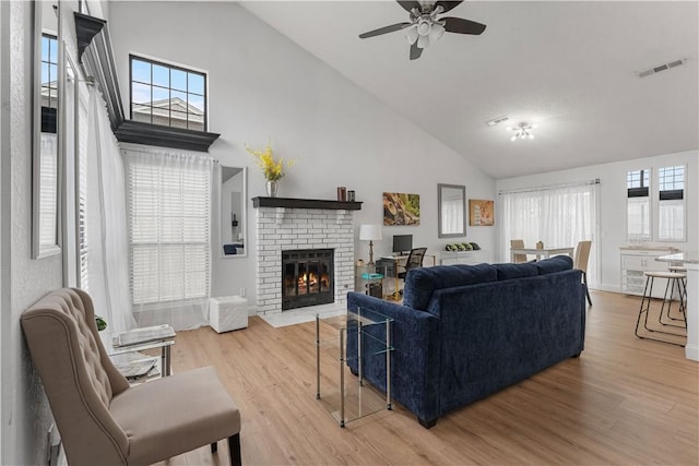 living room featuring plenty of natural light, high vaulted ceiling, and light wood-type flooring