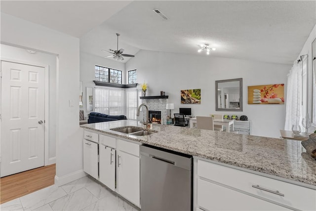 kitchen with white cabinetry, vaulted ceiling, sink, and stainless steel dishwasher