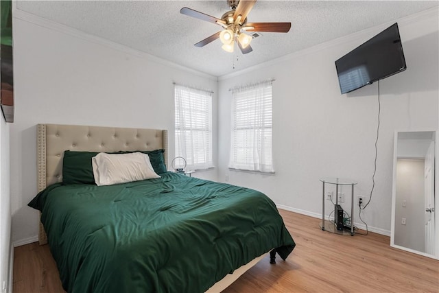 bedroom featuring crown molding, ceiling fan, wood-type flooring, and a textured ceiling