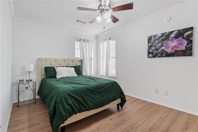 bedroom with crown molding, ceiling fan, wood-type flooring, and a textured ceiling